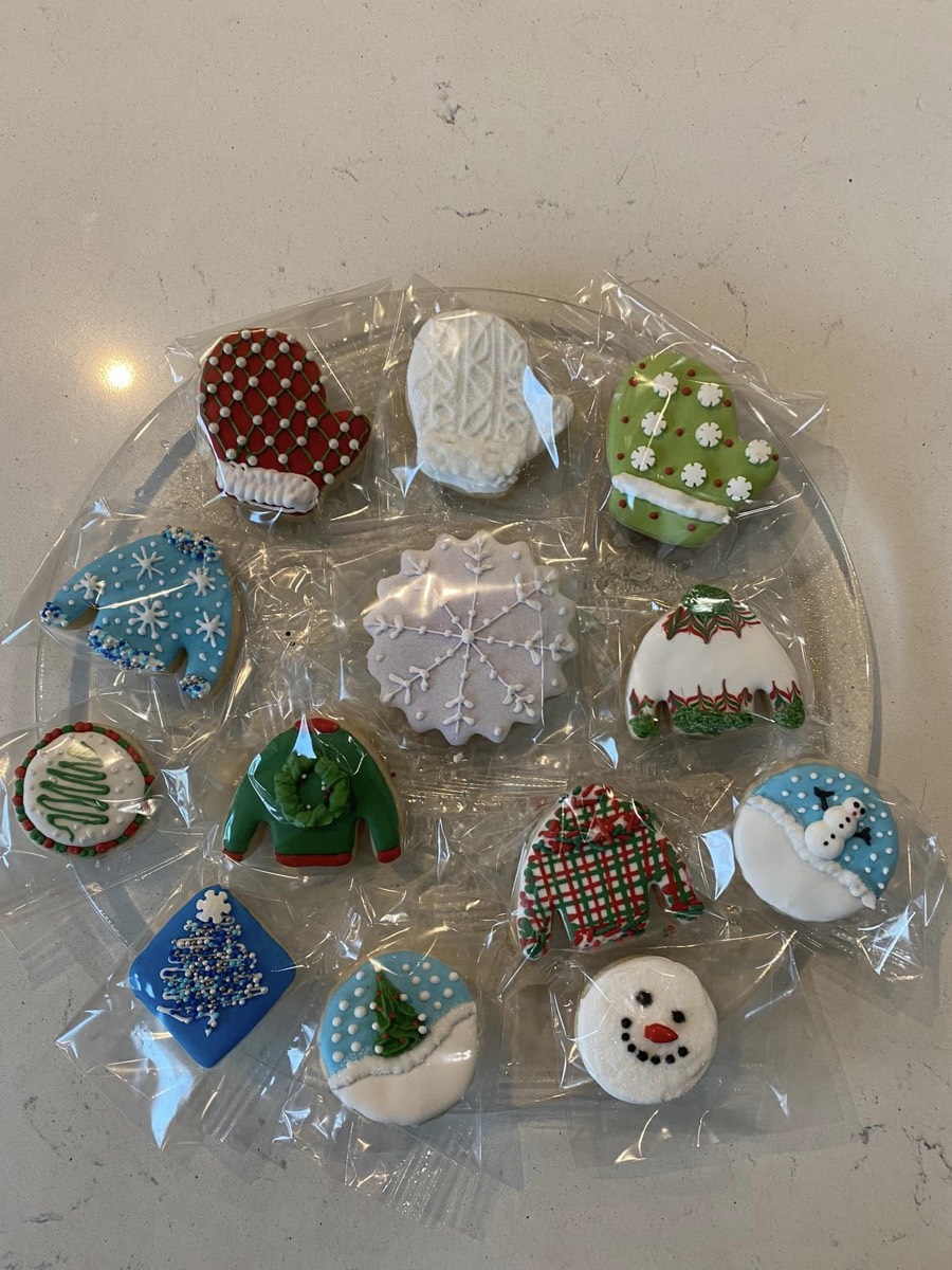 Christmas themed decorated sugar cookies with mittens, snowflakes, and holiday tree designs